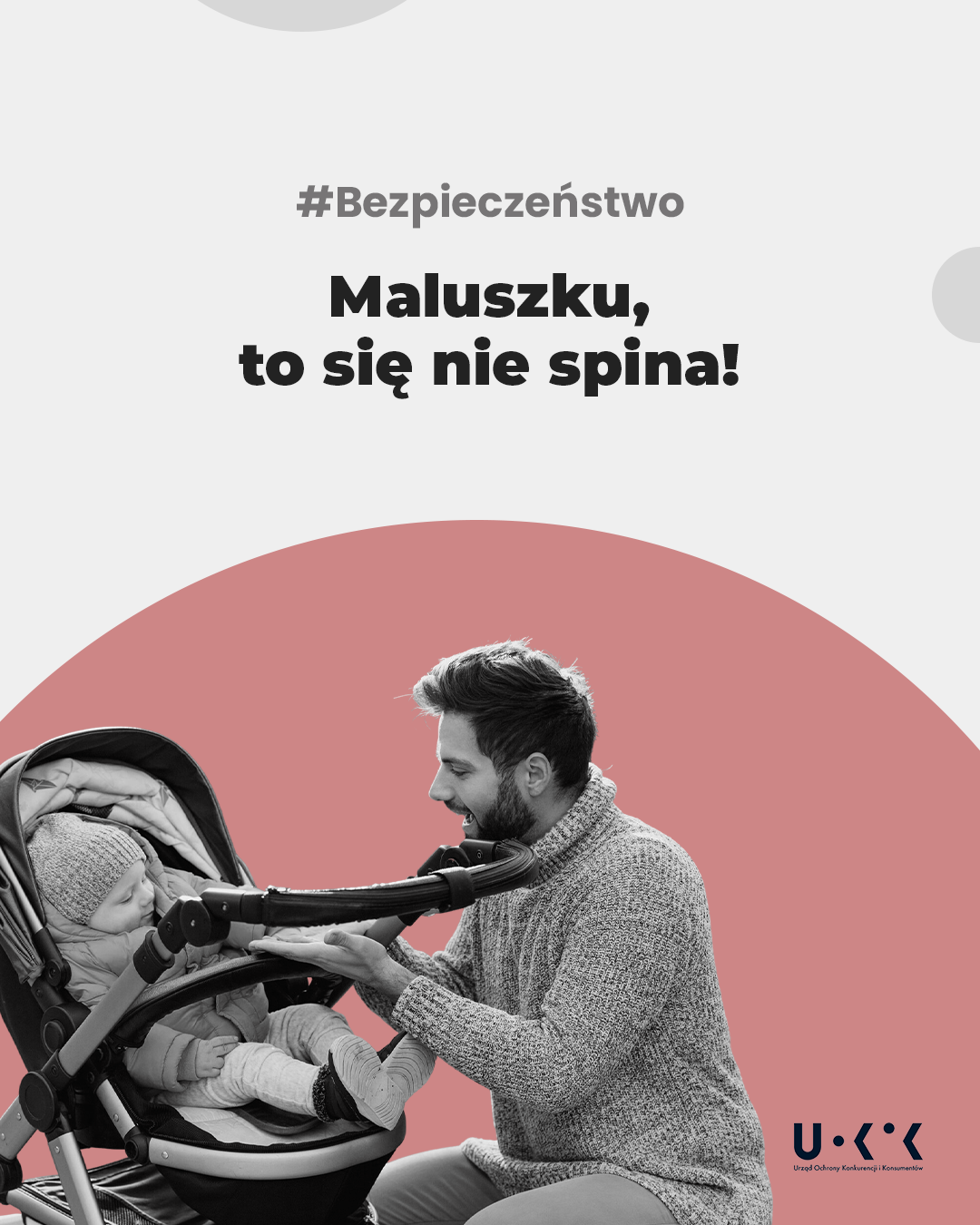 Zdjęcie przedstawia tatę siedzącego przy wózku, w którym znajduje się dziecko, powyzęj napis: #Bezpieczeństwo, poniżej napis: Maluszku, to się nie spina!